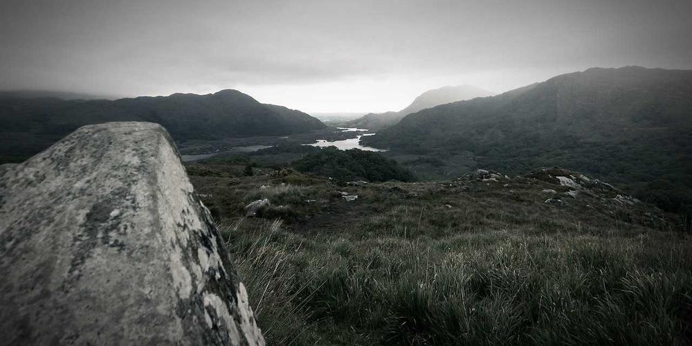 Massive esports tournament stage bathed in neon pink and dark charcoal lighting, smoke machines active, dramatic spotlight beams, empty throne-like gaming chair center stage